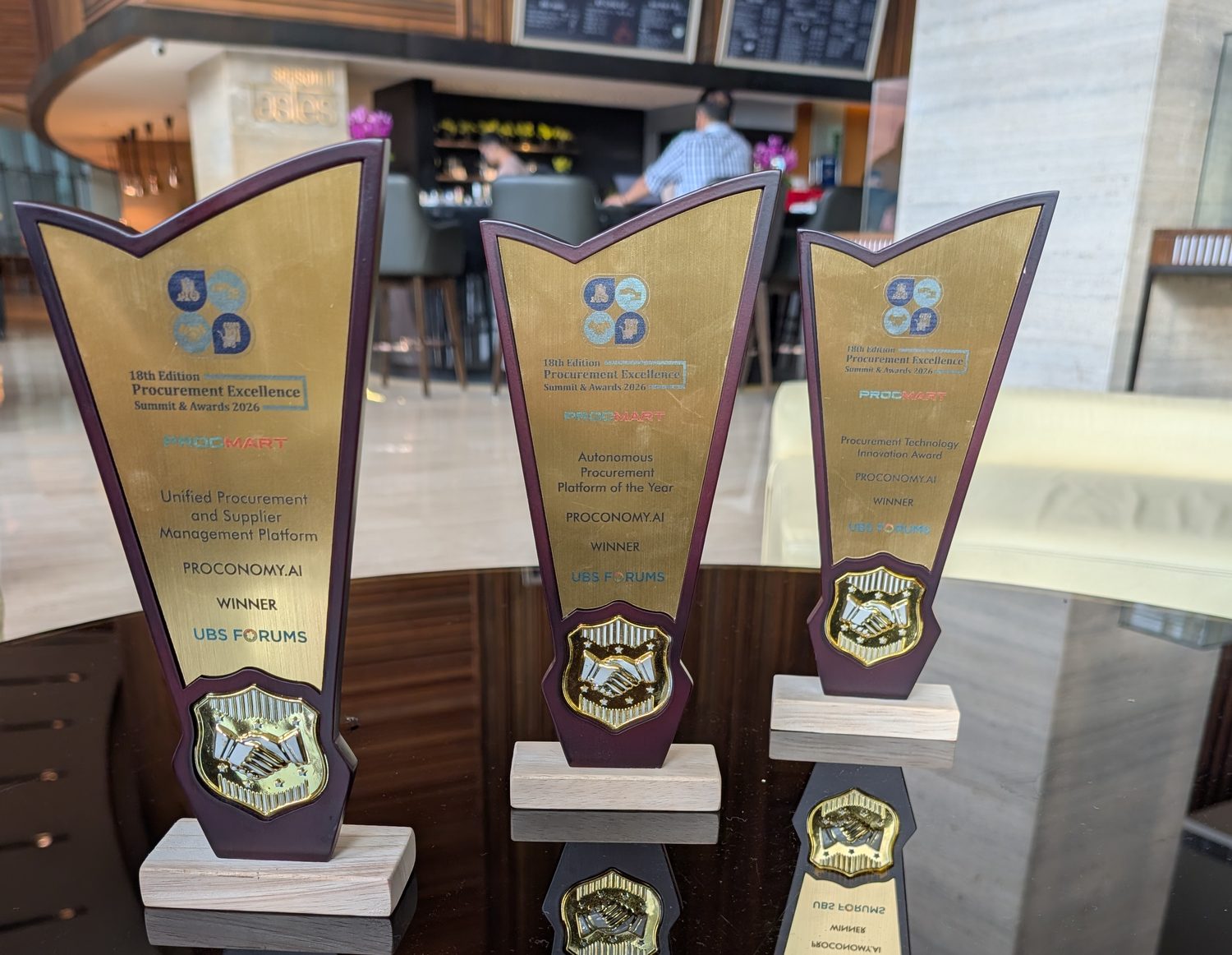 Three engraved trophies from the 18th Edition Procurement Excellence Summit and Awards 2026, each reading Proconomy.ai, Winner, UBS Forums